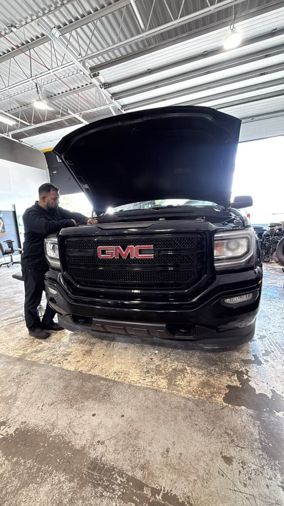 Sikandar, senior technician, performing engine service on a GMC truck